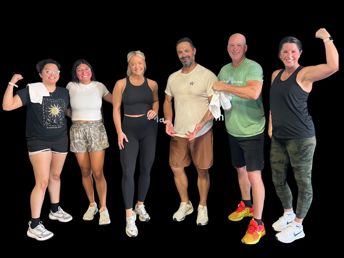 Majestic Fitness members posing indoors with a large tractor tire